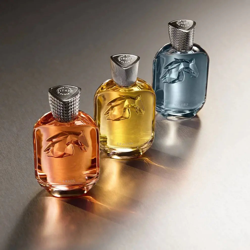 בושם Parfums de Marly מקולקציית Les Extraits: Eragon, Valero ו-Carios יוניסקס 100 מ"ל, זווית צילום יוקרתית המדגישה את הנוכחות של שלושת הניחוחות על השידה.